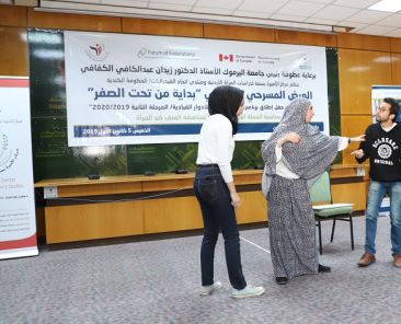 Three people standing at the front of the room at a presentation in the MENA region