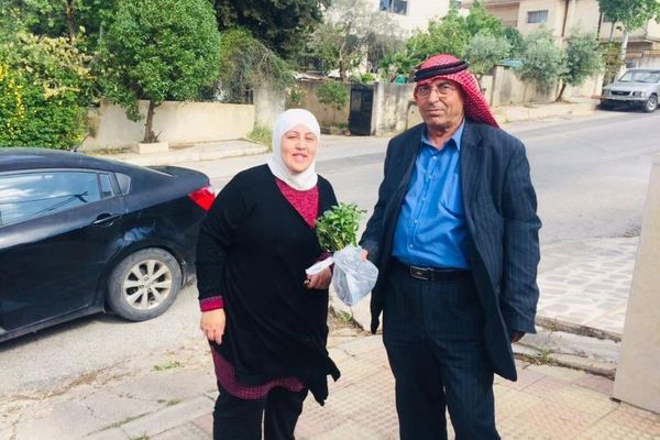 Reema Zghoul standing beside a man holding seedlings in Jordan