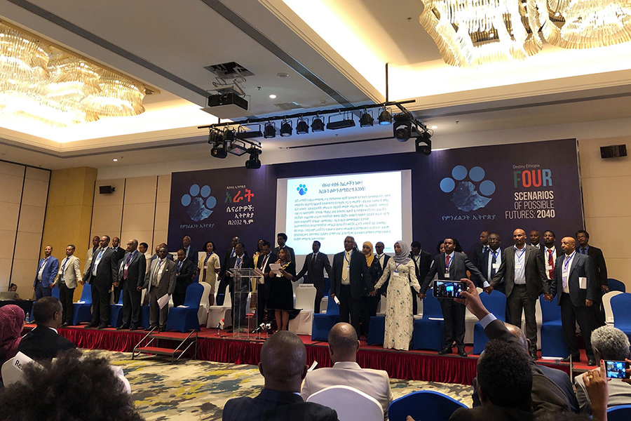 Leaders from across Ethiopian society stand on stage holding hands during the Four Scenarios of Possible Futures: 2040 Conference