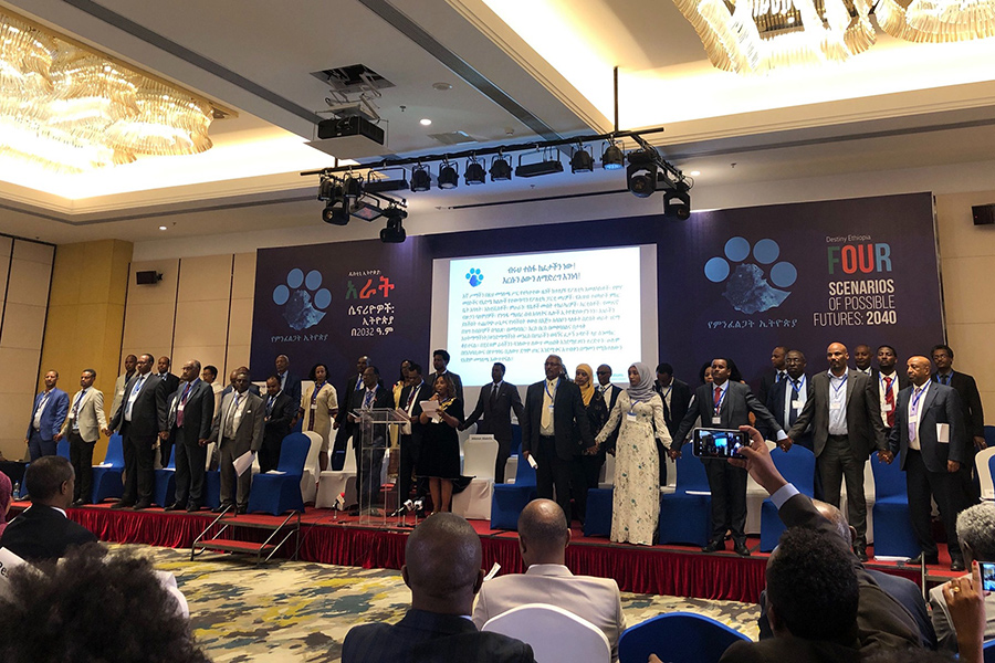 Leaders from across Ethiopian society stand on stage holding hands during the Four Scenarios of Possible Futures: 2040 Conference