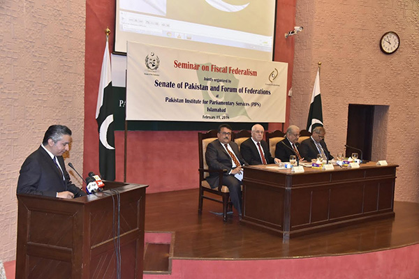 Man speaks at podium during Seminar on Fiscal Federalism in Pakistan